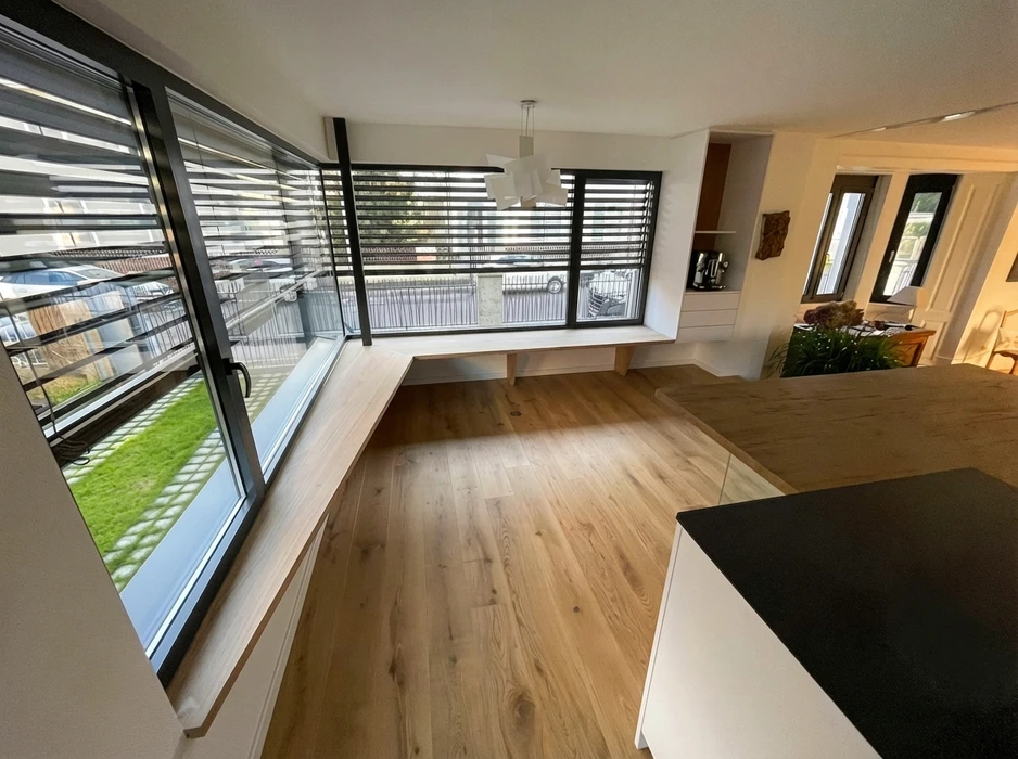 Intérieur résidentiel moderne, meuble bas sur-mesure en laque ivoire avec plateau en chêne naturel, intégré sous un escalier