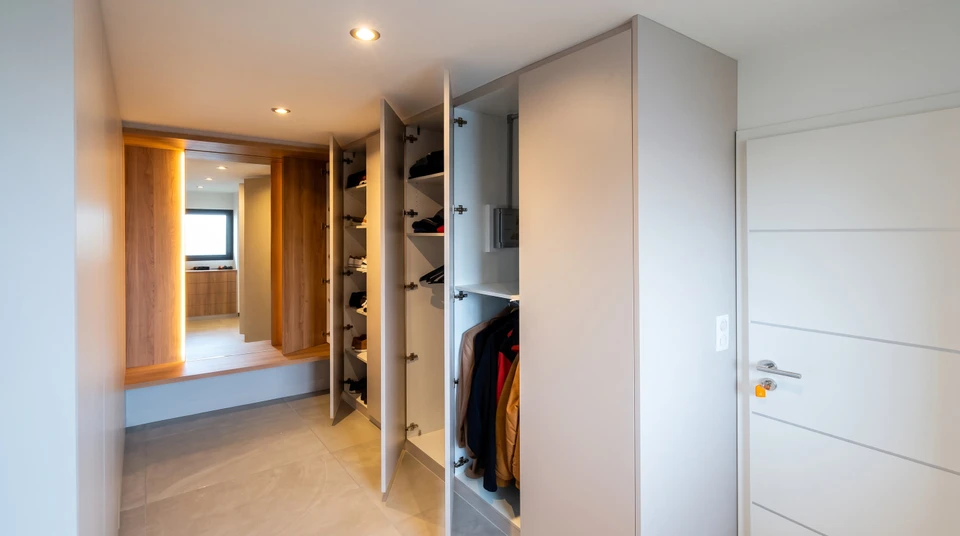 Dressing moderne sur mesure avec aménagement optimisé comprenant penderies doubles niveaux, étagères d'angle, tiroirs multiples et rangements compartimentés