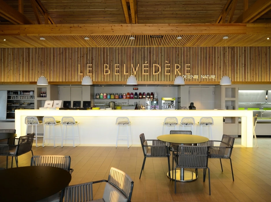 Cuisine aménagée en combles avec plan de travail vert olive en L, façades de meubles bas en stratifié imitation noyer, poignées noires