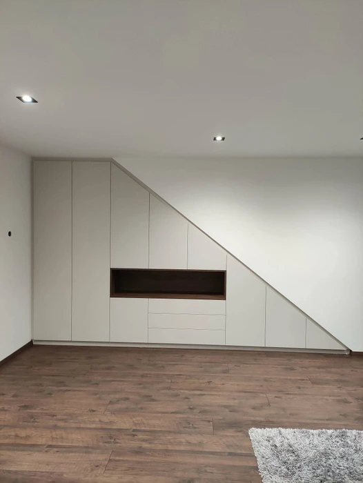 Salon minimaliste vide, mur gris clair, parquet chêne clair