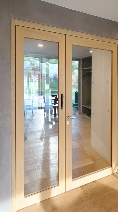 Intérieur résidentiel moderne, meuble bas sur-mesure en laque ivoire avec plateau en chêne naturel, intégré sous un escalier