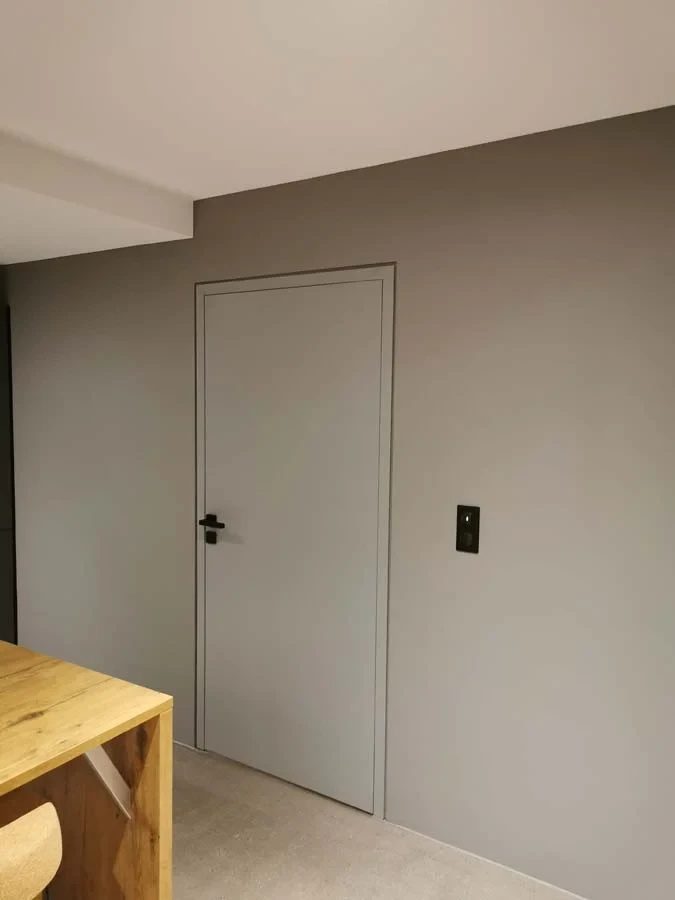Intérieur résidentiel moderne, meuble bas sur-mesure en laque ivoire avec plateau en chêne naturel, intégré sous un escalier