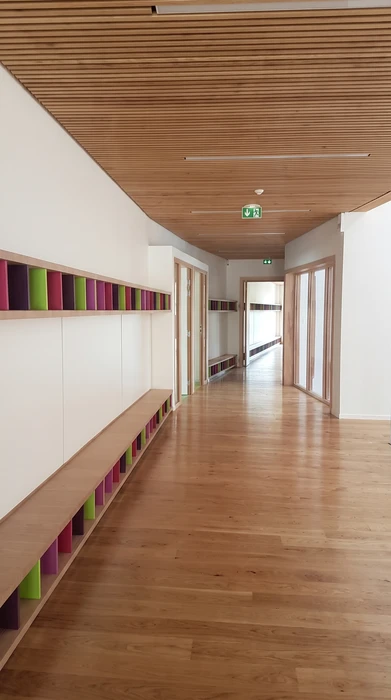 Intérieur résidentiel moderne, meuble bas sur-mesure en laque ivoire avec plateau en chêne naturel, intégré sous un escalier