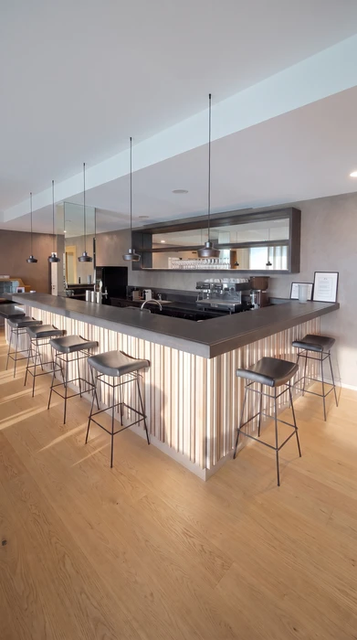 Intérieur résidentiel moderne, meuble bas sur-mesure en laque ivoire avec plateau en chêne naturel, intégré sous un escalier